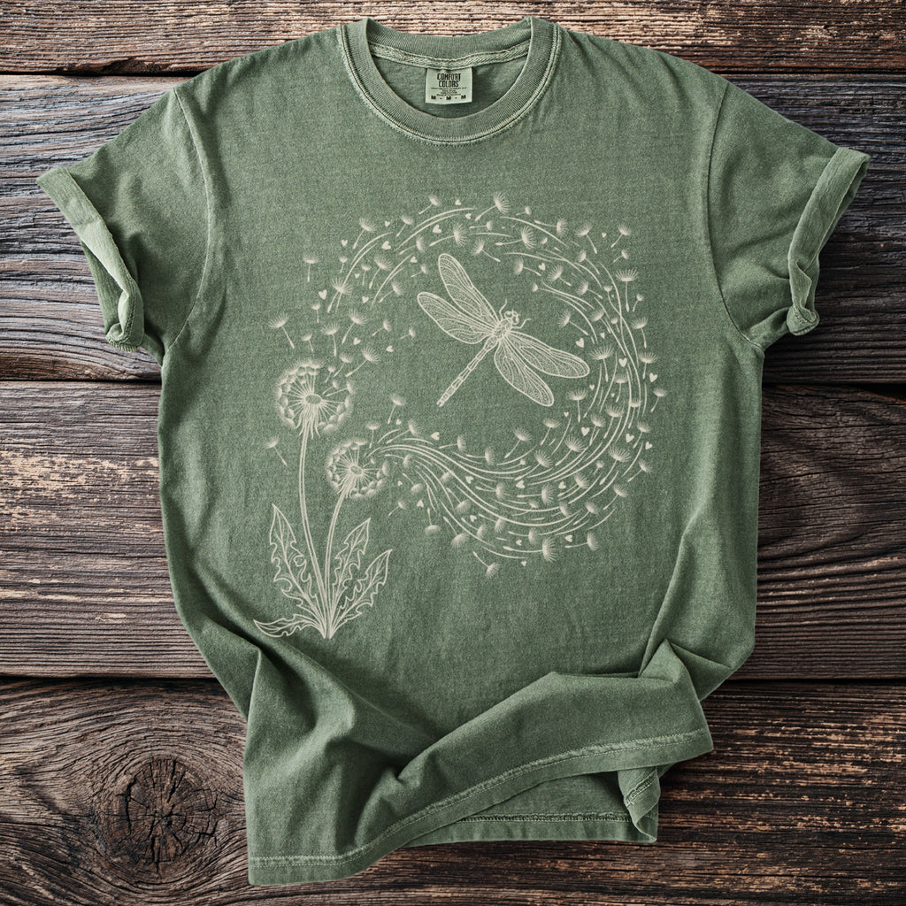 Green t-shirt with a white line drawing of a dragonfly and dandelions.