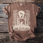 Brown t-shirt with woodland scene featuring two wolves and rune-decorated gate.