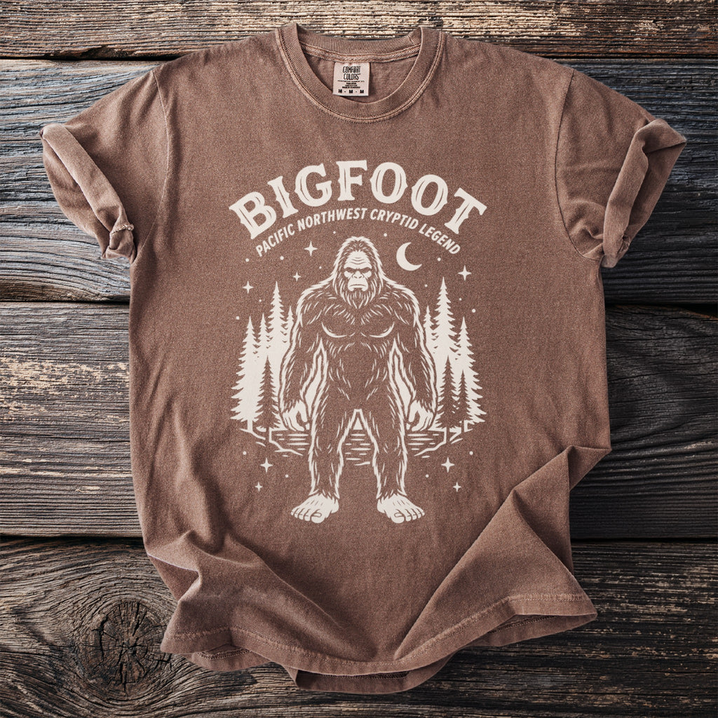 Brown t-shirt with Bigfoot graphic: Pacific Northwest Cryptid Legend.