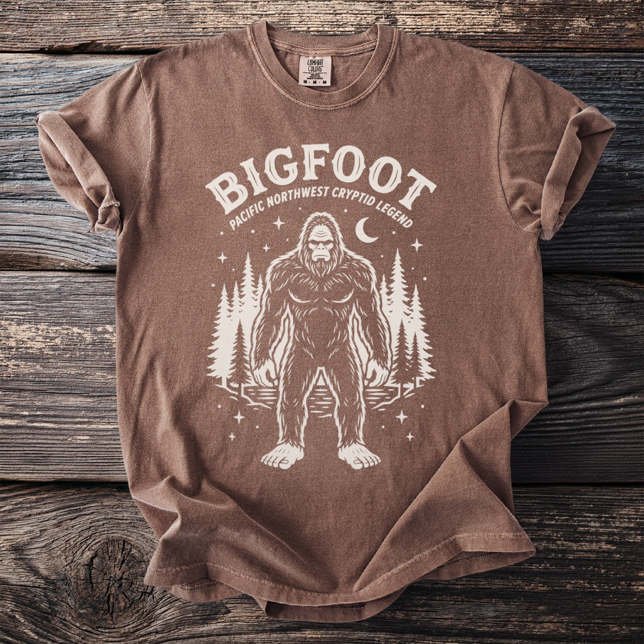 Brown t-shirt with Bigfoot graphic: Pacific Northwest Cryptid Legend.