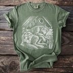 Green t-shirt with a drawing of a sleeping wolf under a crescent moon and star.