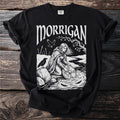 Black t-shirt with white "MORRIGAN" text and illustration of woman by water.