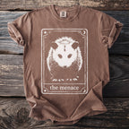 Brown t-shirt with white opossum tarot card graphic and text "the menace".