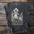 Graphic tee with alien, UFO, trees, and people holding flashlights.