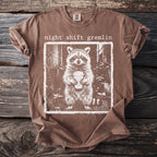 Brown t-shirt with "night shift gremlin" and raccoon holding coffee mug graphic.