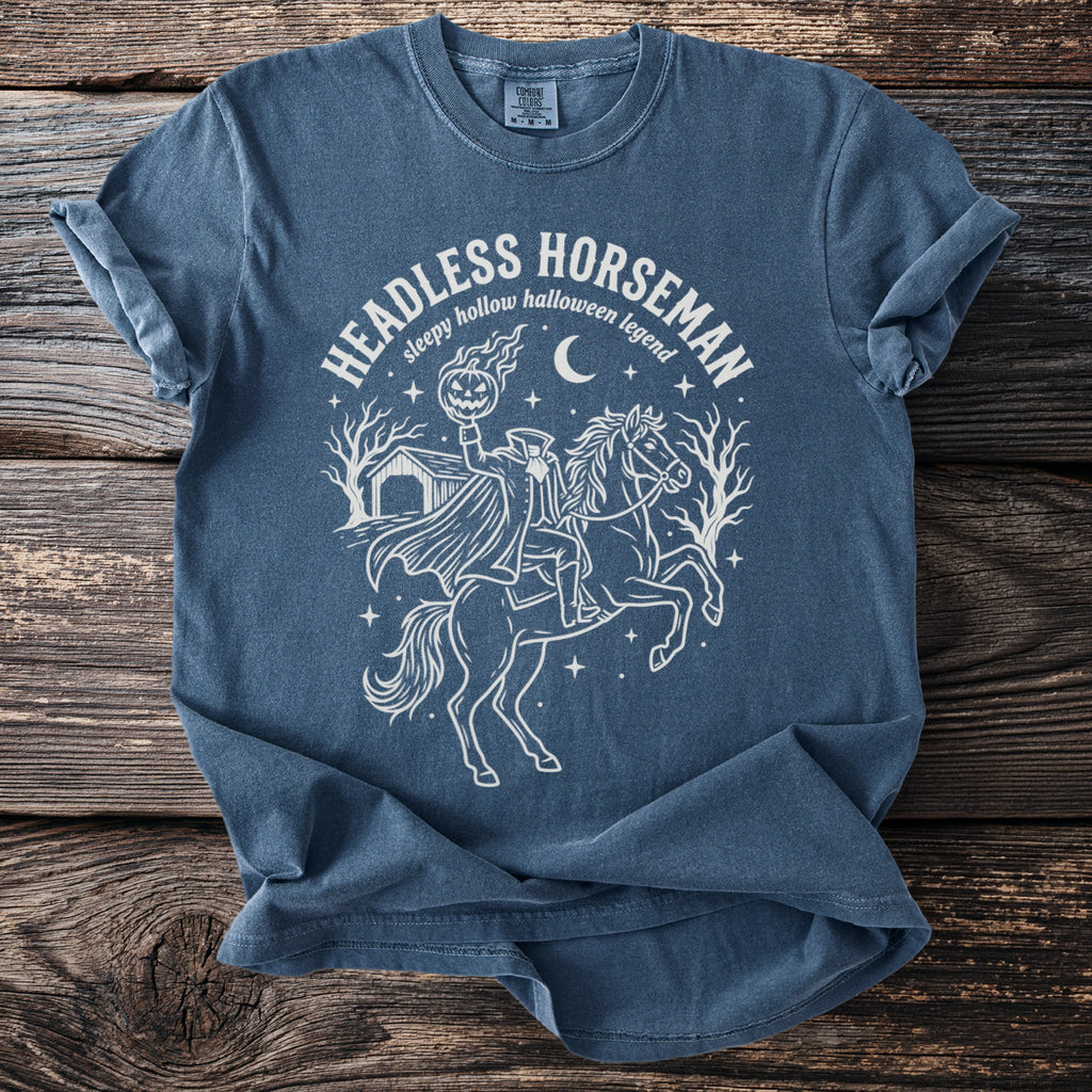 T-shirt with a white line drawing of the Headless Horseman holding a pumpkin and riding a horse.