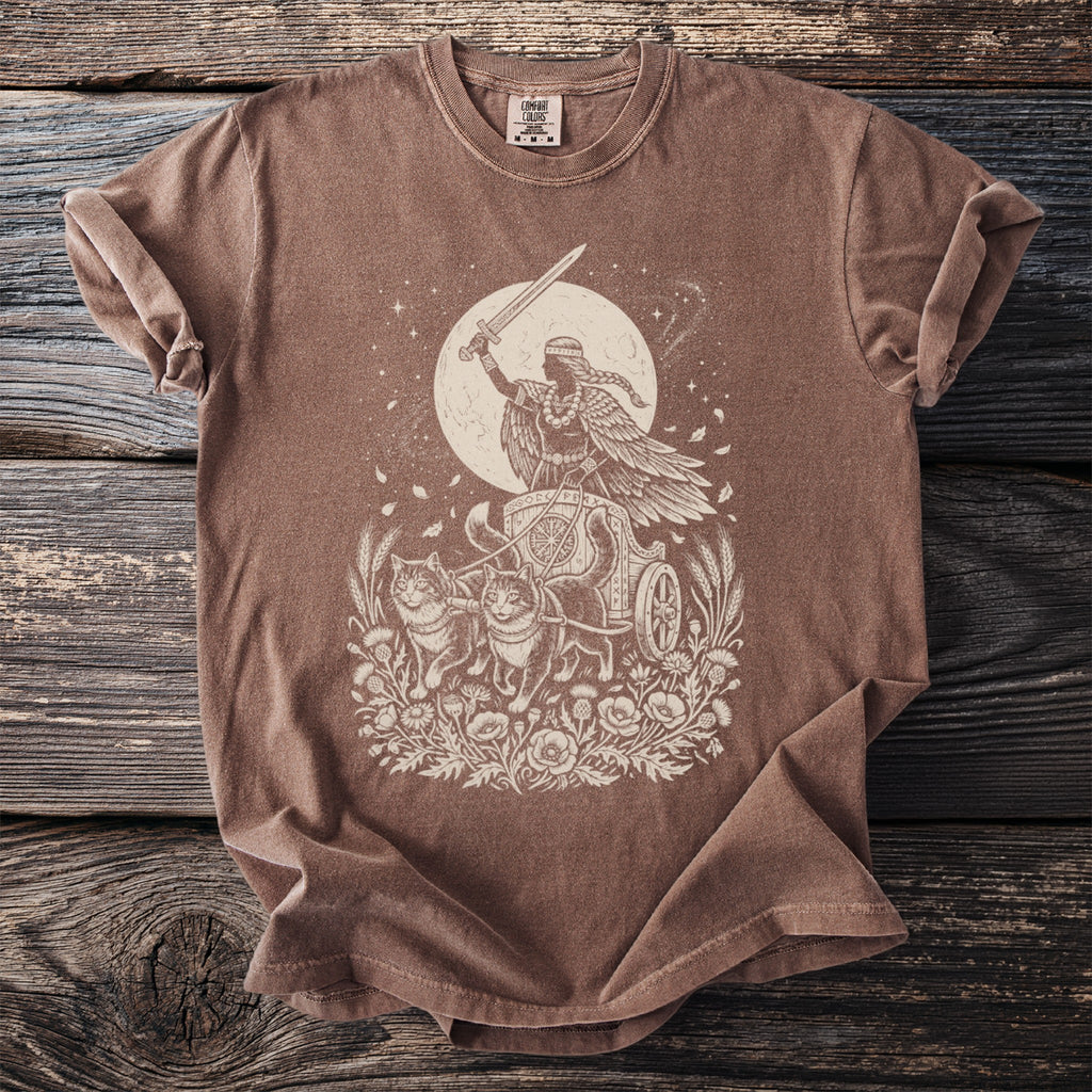 Brown Comfort Colors t-shirt with a line drawing of a winged figure in a chariot pulled by cats.