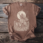 Brown Comfort Colors t-shirt with a line drawing of a winged figure in a chariot pulled by cats.