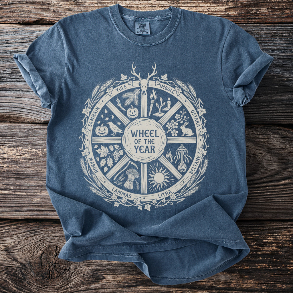 Blue t-shirt featuring a circular "Wheel of the Year" design with pagan holiday names.