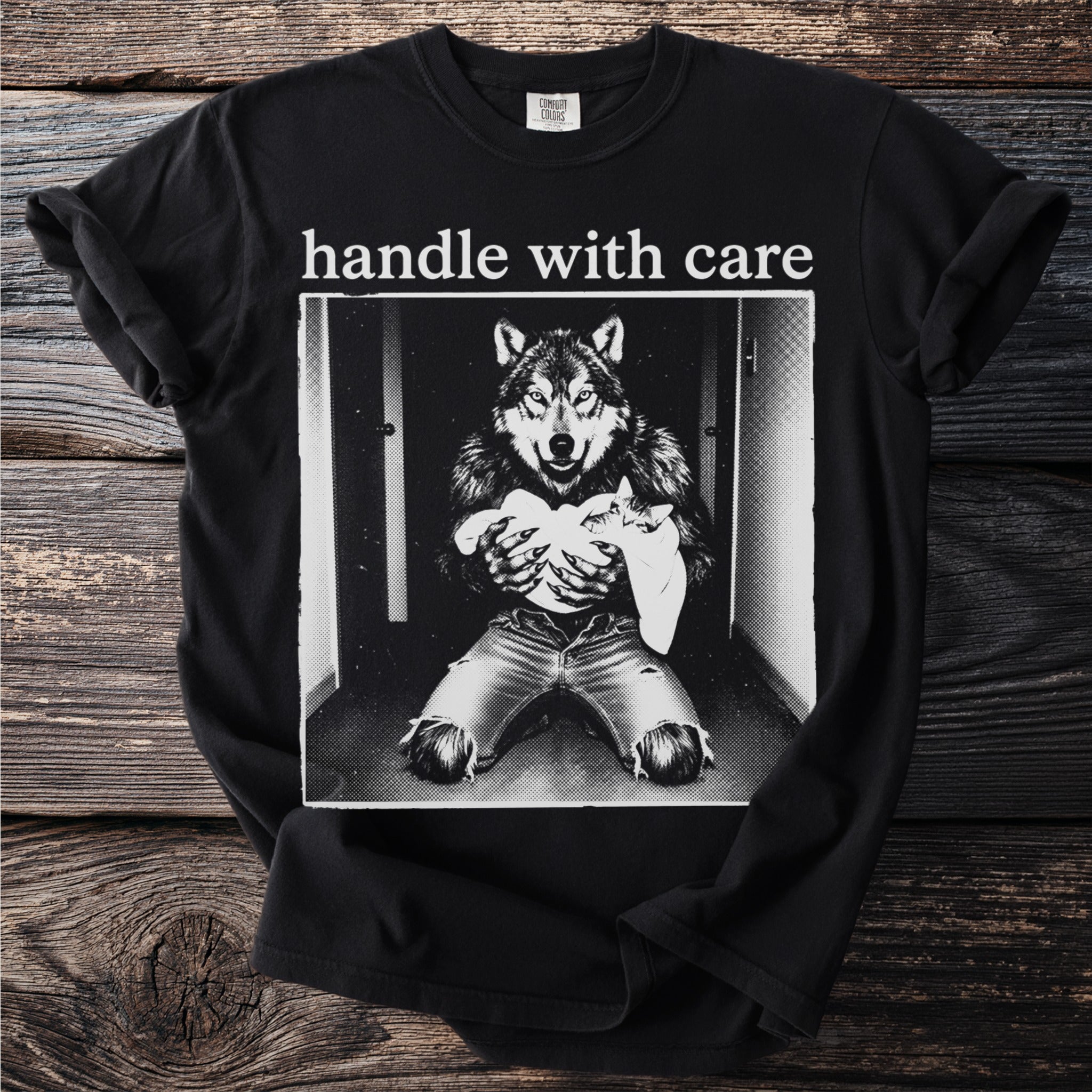 Black t-shirt with "handle with care" and wolf holding a kitten graphic.