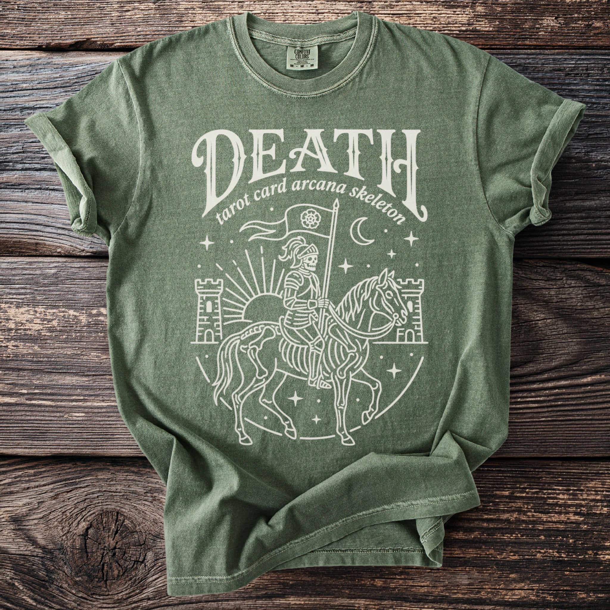 Green t-shirt with a white line drawing of a skeleton knight on a horse, with castles and stars.