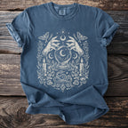 Blue t-shirt with mystical graphic featuring hands, crystal ball, snake, moths, candles, and crystals.