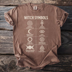 Brown t-shirt displaying "WITCH SYMBOLS" with eight astrological and symbolic icons and their descriptions.
