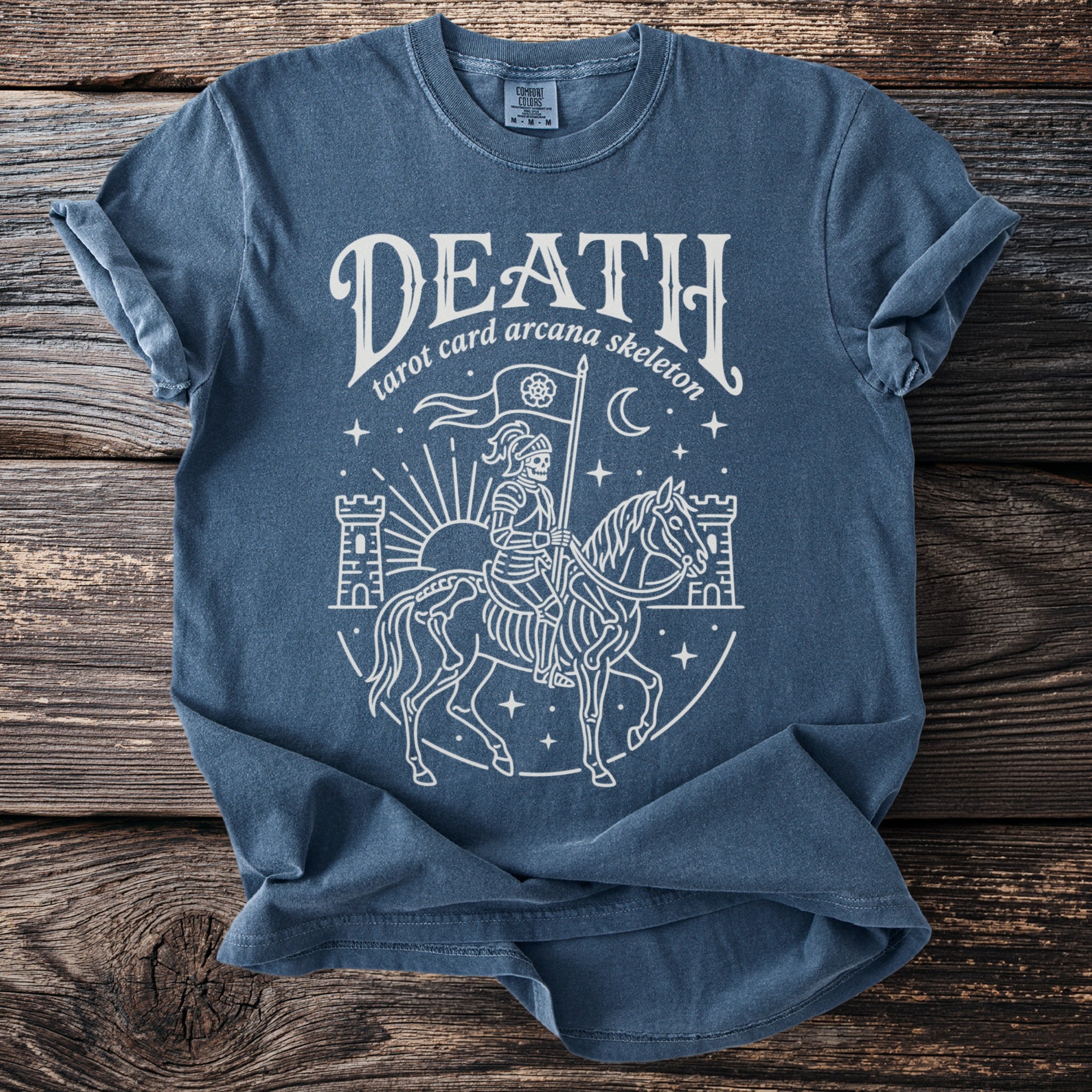 Blue t-shirt with white graphic of skeleton on horseback and "DEATH tarot card arcana skeleton" text.