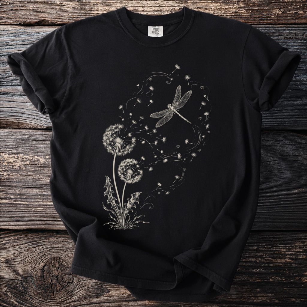 Black t-shirt with a cream-colored line drawing of dandelions and a dragonfly.
