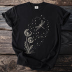 Black t-shirt with a cream-colored line drawing of dandelions and a dragonfly.