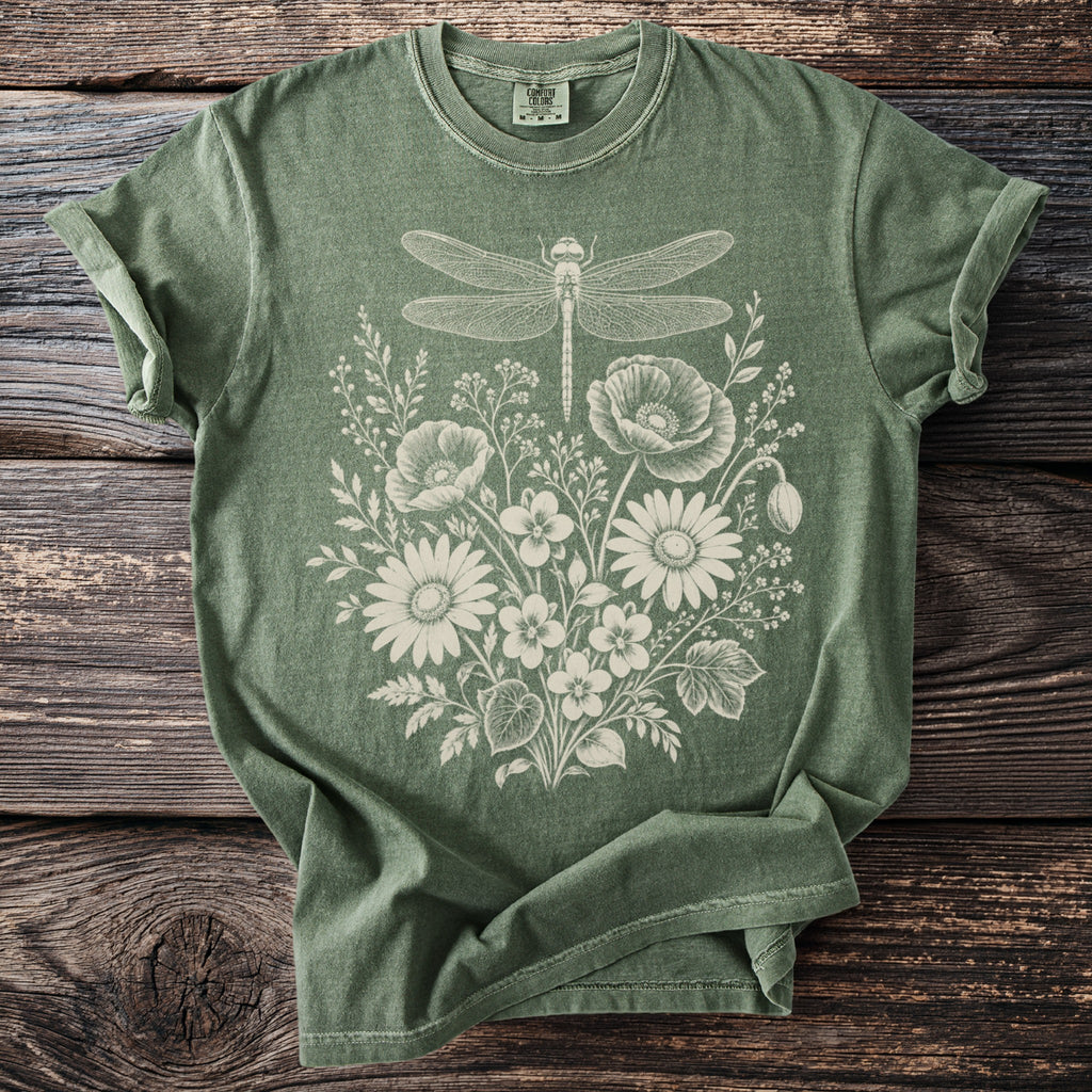 Green t-shirt with white dragonfly and floral line art graphic.