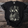 Black t-shirt with cream graphic of a witch tied to a stake amidst flames.