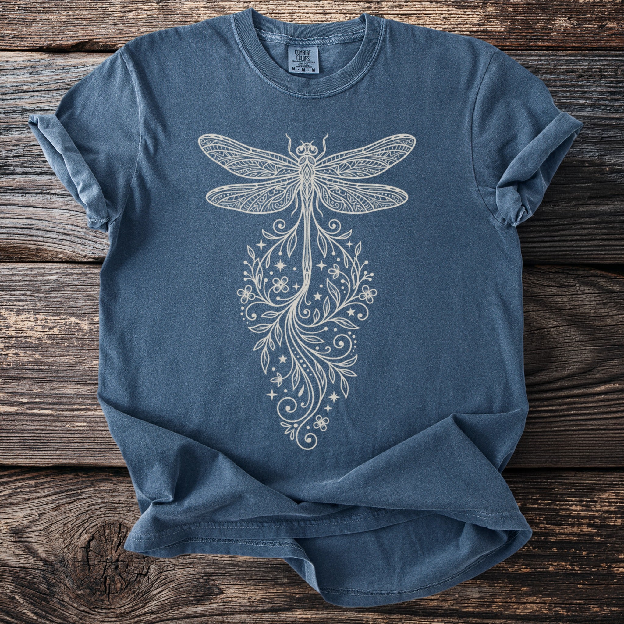 Blue t-shirt with a detailed cream dragonfly and floral design.