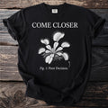 Black t-shirt with "COME CLOSER" and a drawing of a Venus flytrap labeled "Fig. 1: Poor Decision."