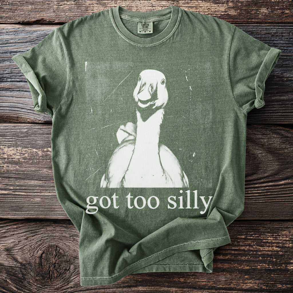 Green t-shirt with a white graphic of a duck face and text "got too silly".