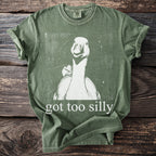 Green t-shirt with a white graphic of a duck face and text "got too silly".