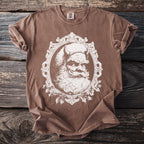 Brown t-shirt with a distressed white illustration of a horned Santa Claus in an ornate frame.