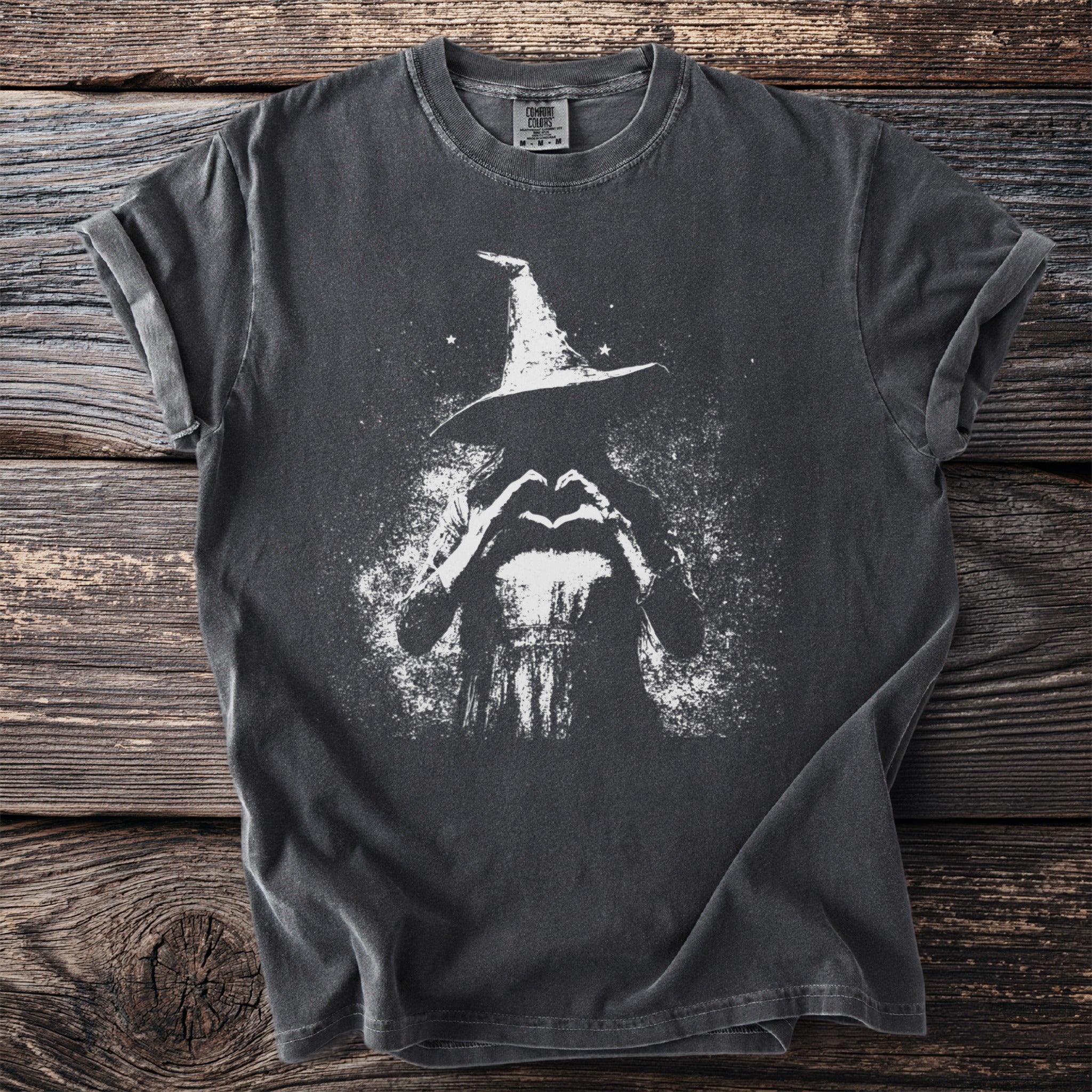 Dark t-shirt with white graphic of a witch making a heart shape with her hands.