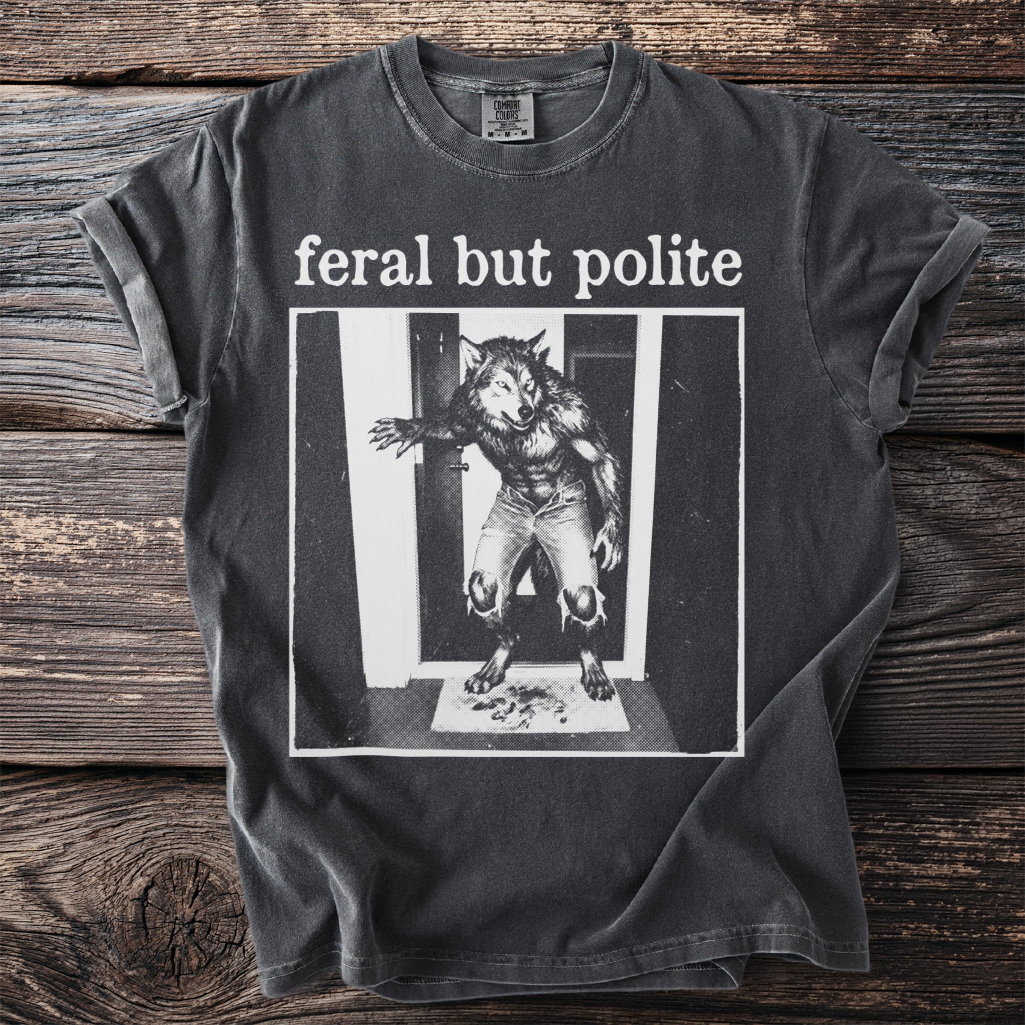Dark grey t-shirt with text "feral but polite" and werewolf graphic.