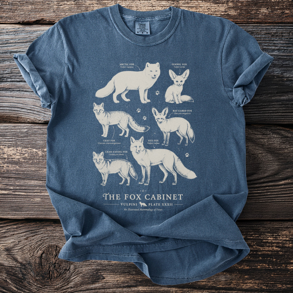 Blue t-shirt with illustrations of five fox species titled "The Fox Cabinet."