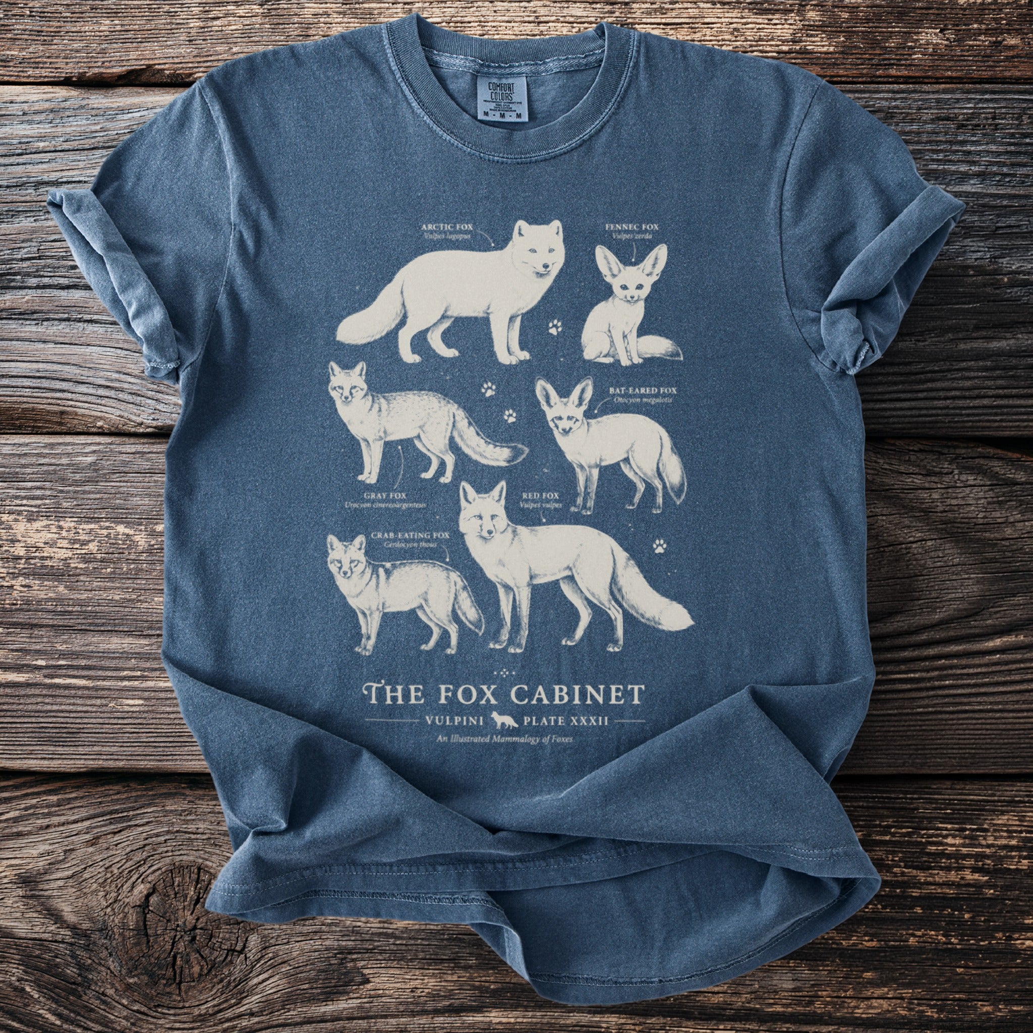 Blue t-shirt with illustrations of five fox species titled "The Fox Cabinet."