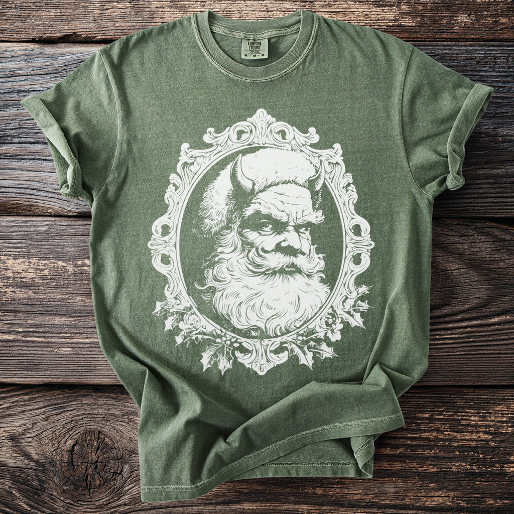 Green t-shirt with a white distressed graphic of a devilish Santa Claus in a frame.