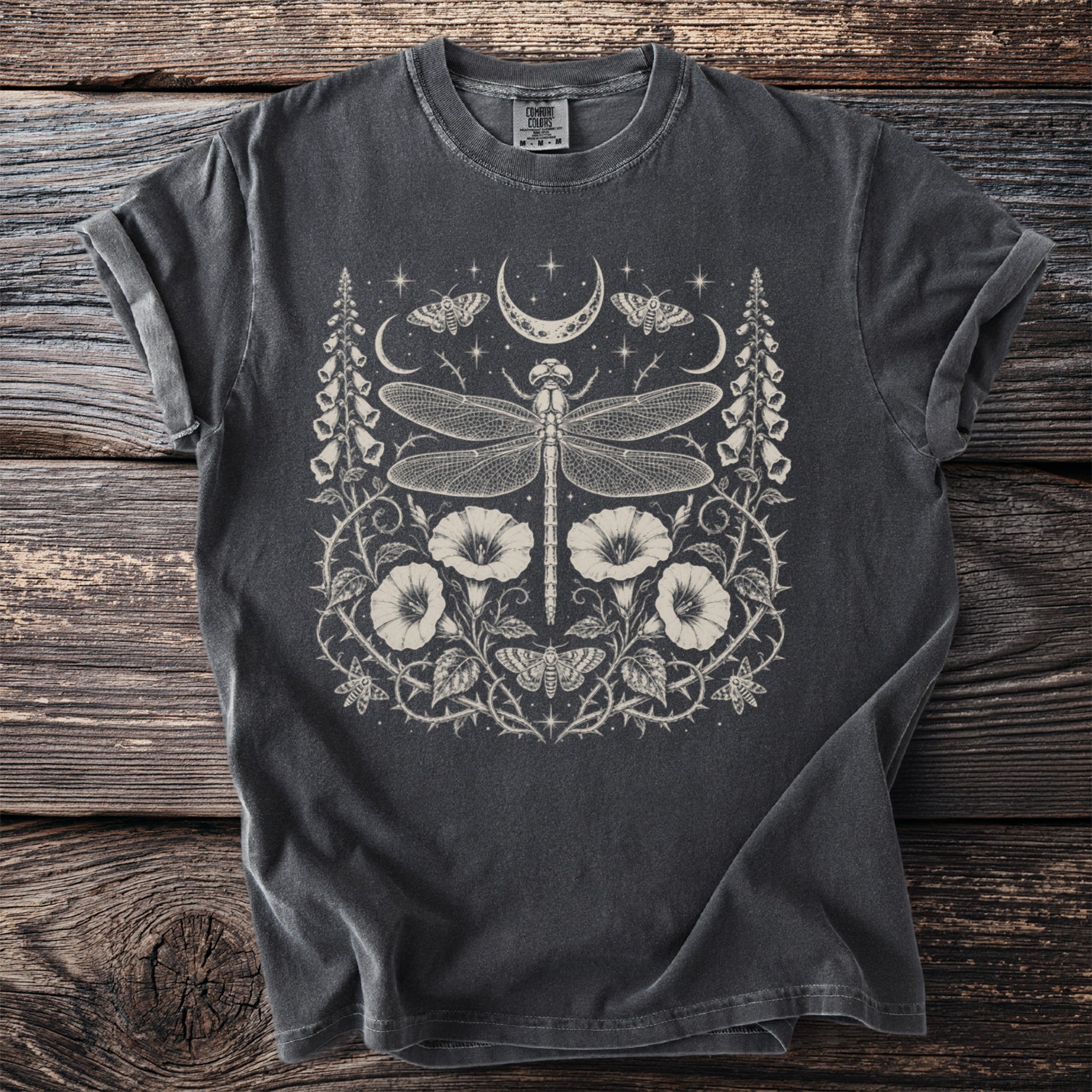 Dark gray t-shirt with a white celestial dragonfly, moths, moon, and floral design.
