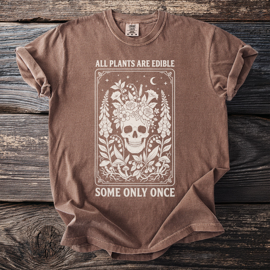 Brown t-shirt with skull and floral design, text says "All Plants Are Edible".