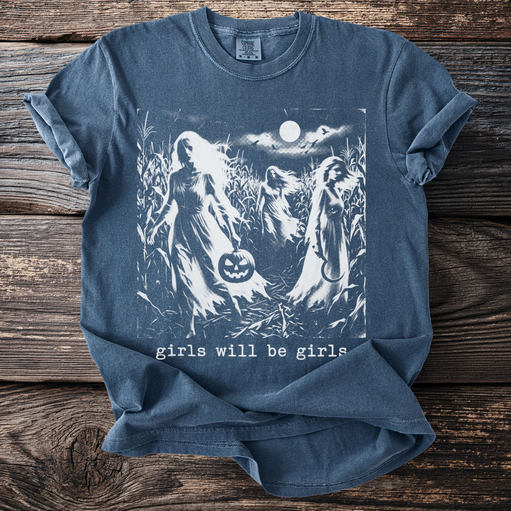 Blue shirt with a screen print of three ghostly figures in a cornfield under a full moon, text reads "girls will be girls".