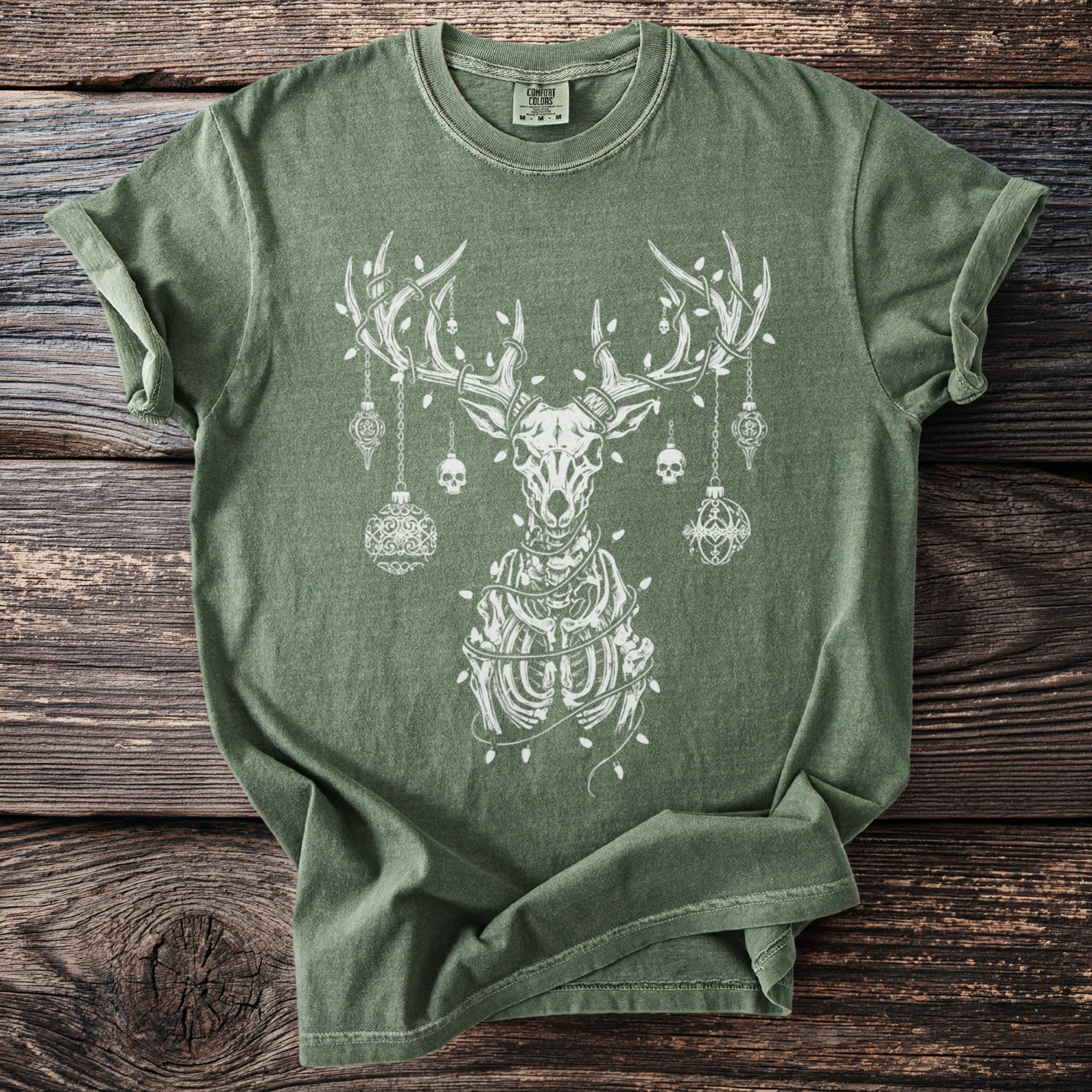 Green t-shirt with a white skeleton reindeer adorned with ornaments and lights.