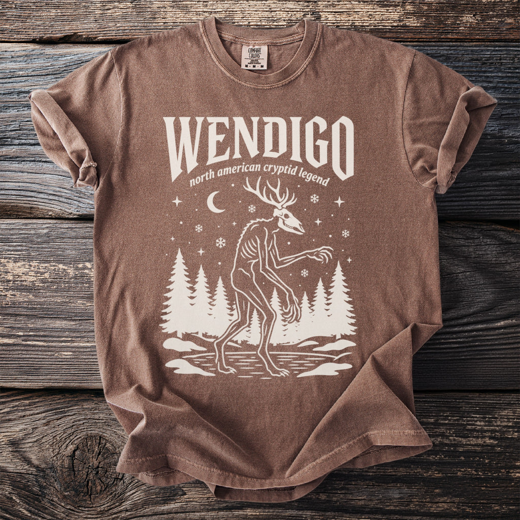 Brown t-shirt with "WENDIGO north american cryptid legend" and a skeletal deer-like creature.