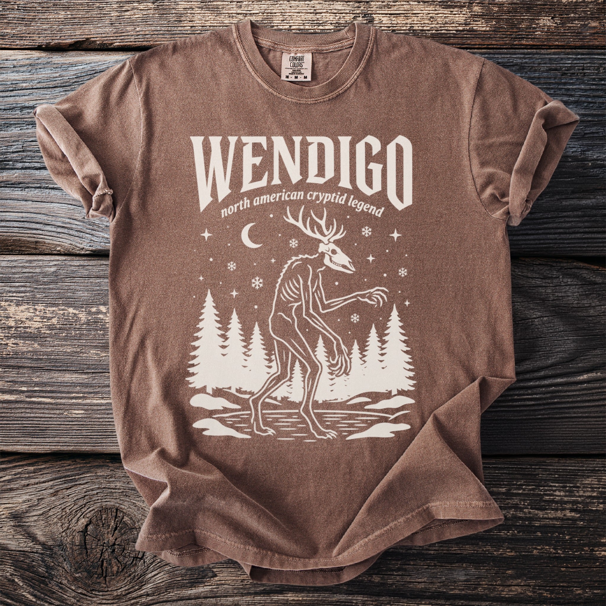 Brown t-shirt with "WENDIGO north american cryptid legend" and a skeletal deer-like creature.