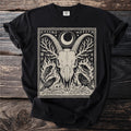 Black t-shirt featuring a print of a ram skull, crows, and runes within a border.