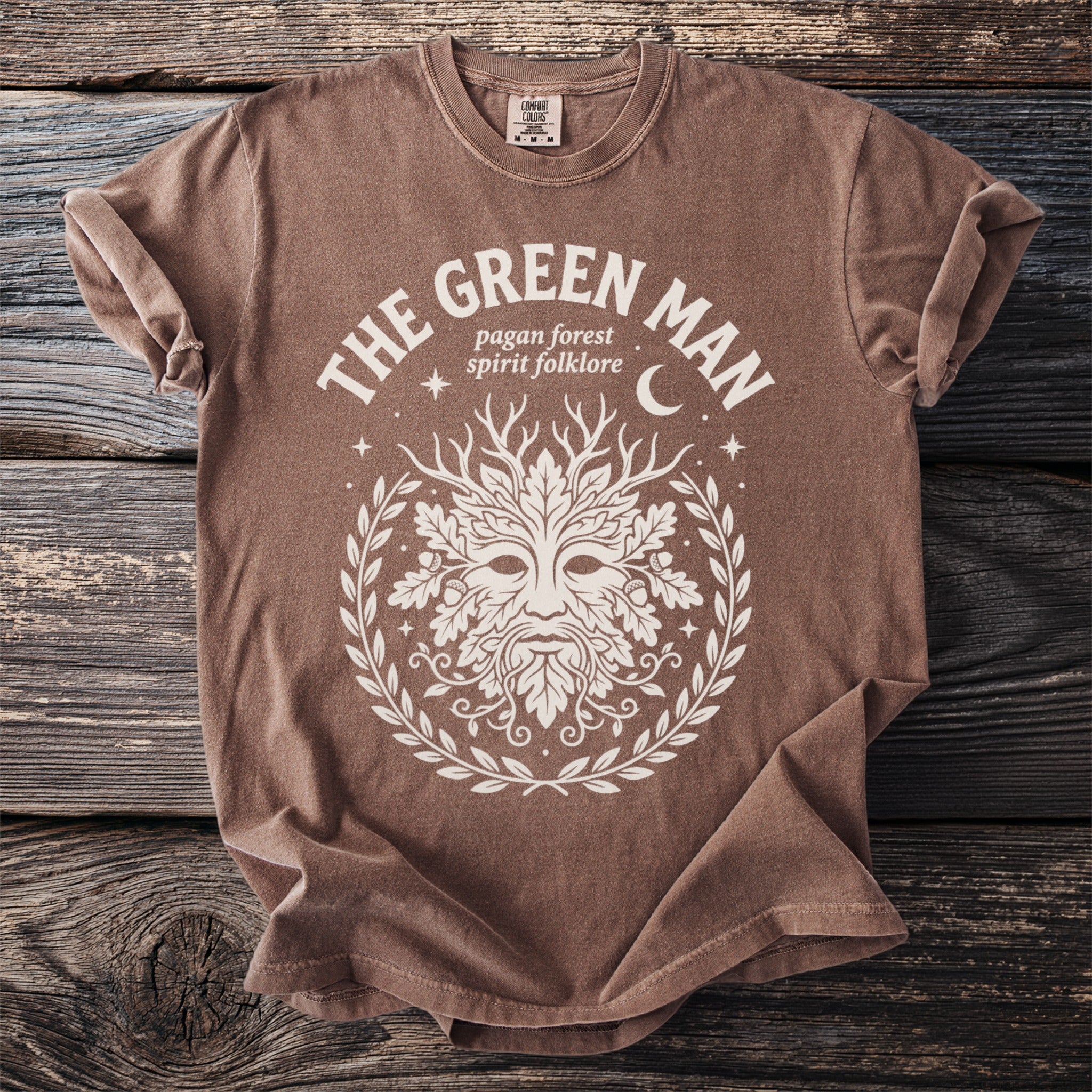 Brown t-shirt with white "The Green Man" graphic and pagan folklore symbols.