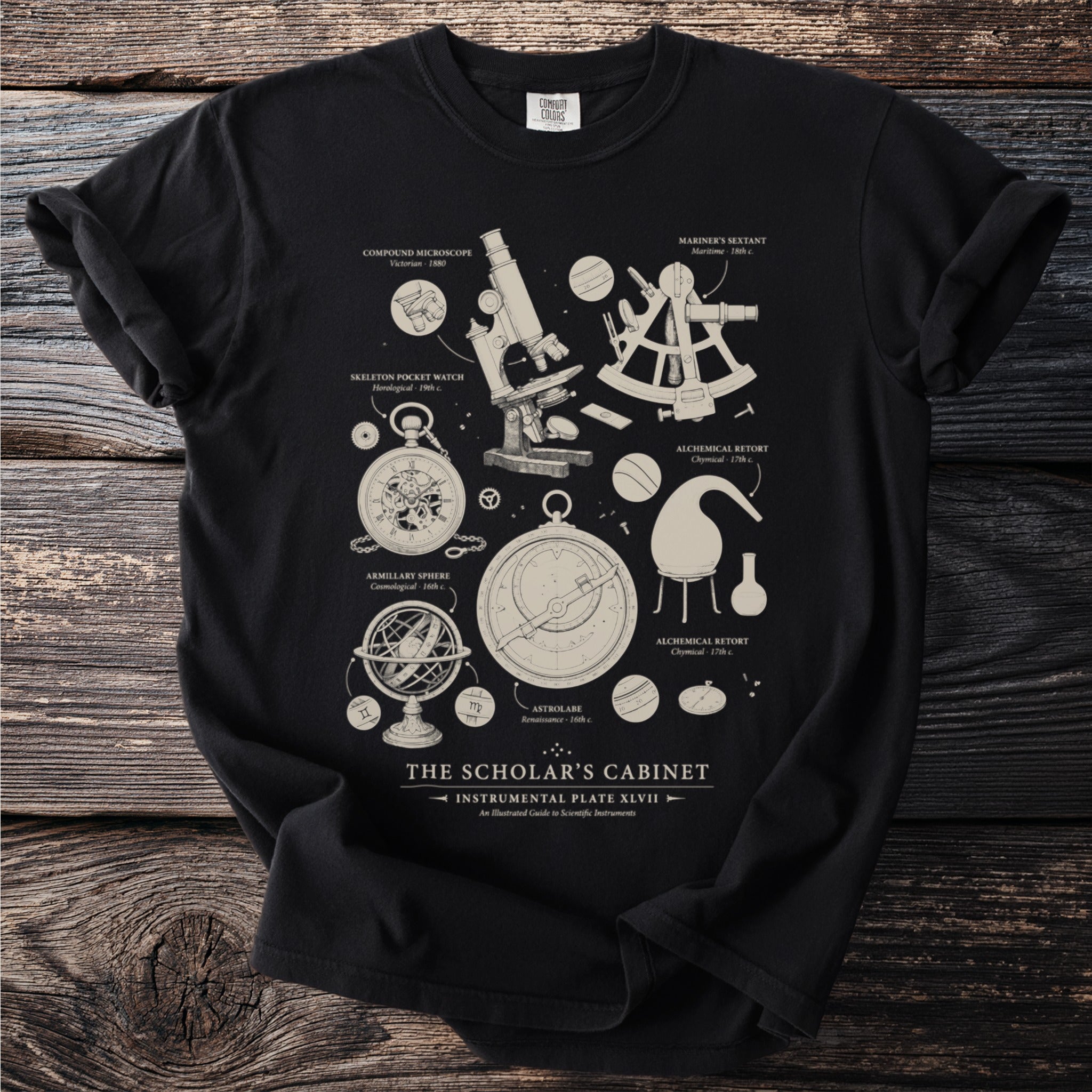 Black t-shirt with "The Scholar's Cabinet" scientific instruments illustration.