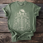 Green t-shirt with Norse-inspired graphic of wolves and a gate under a full moon.