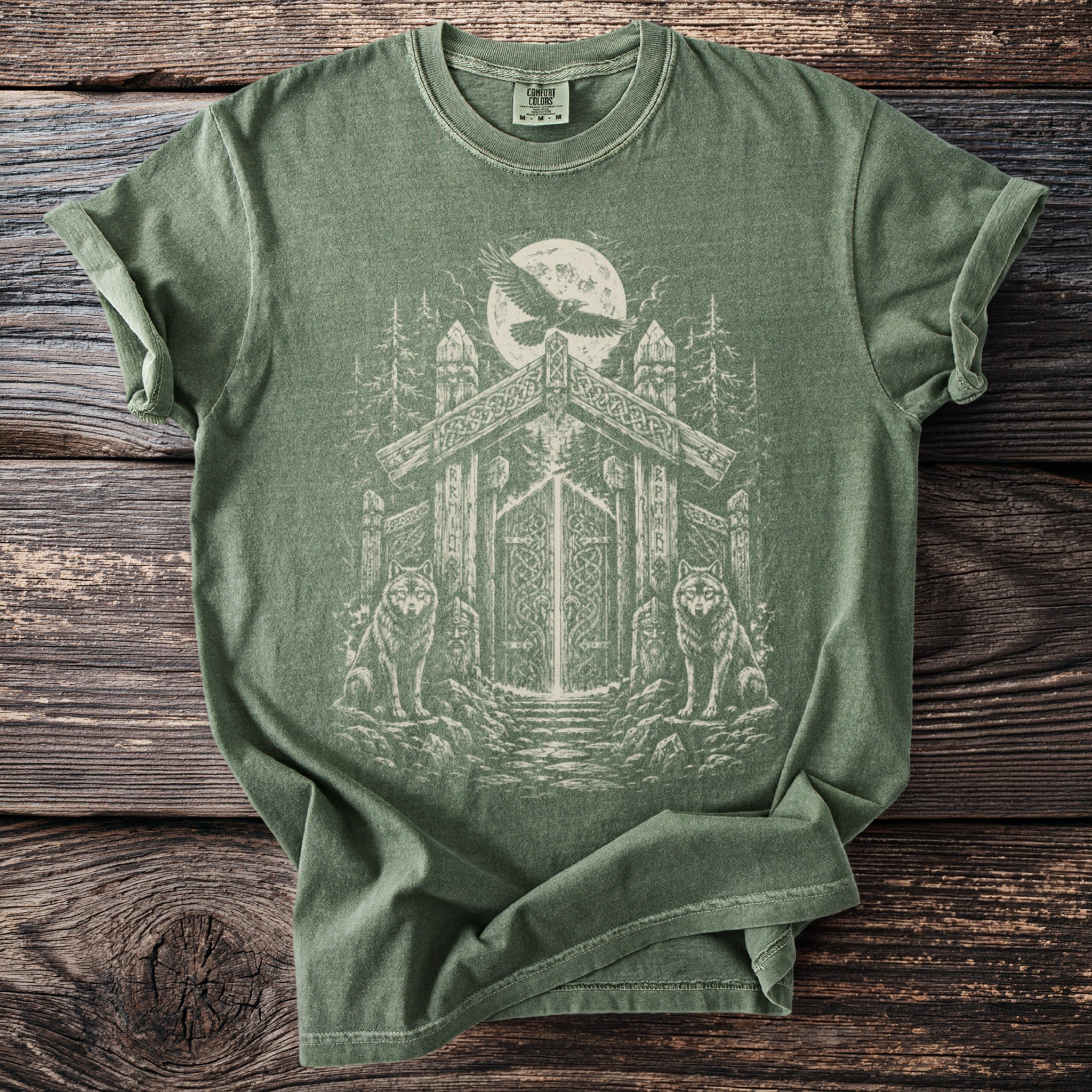 Green t-shirt with Norse-inspired graphic of wolves and a gate under a full moon.