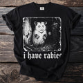 Black t-shirt with white graphic of a possum and text "i have rabies".