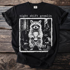 Black t-shirt with "night shift gremlin" text and raccoon holding coffee cup graphic.