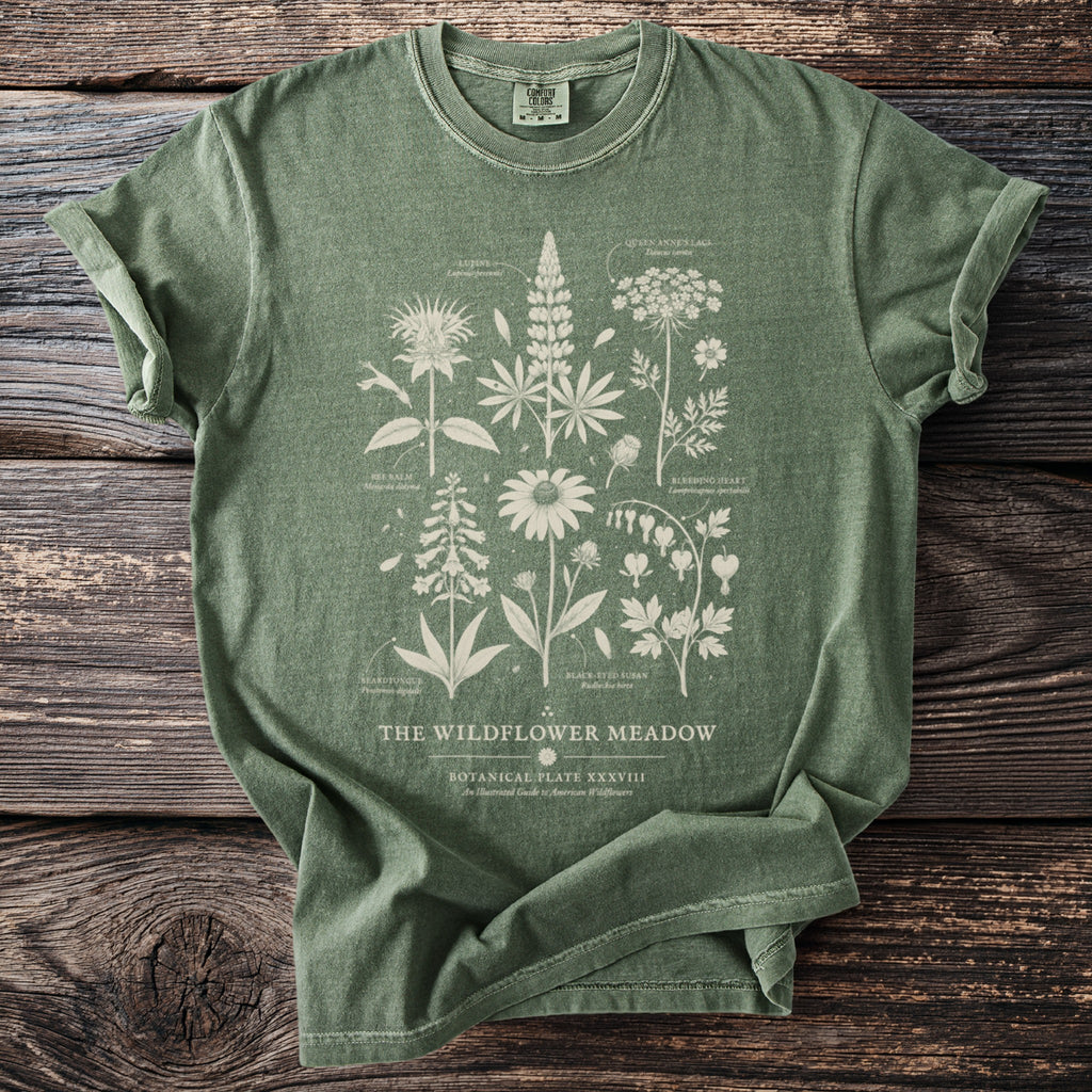 Green t-shirt with botanical illustration of "The Wildflower Meadow" and plant names.
