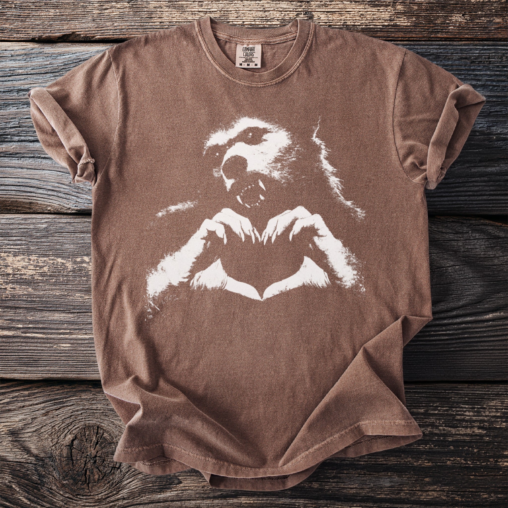 Brown t-shirt with white werewolf and heart hands graphic.