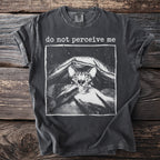 Dark gray t-shirt with a distressed print of a shy cat peeking from under a blanket and the text "do not perceive me".
