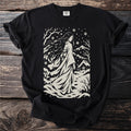 Black t-shirt with a cream stencil design of a woman in a snowy landscape with a cabin.
