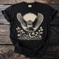 Black t-shirt featuring a detailed linocut-style print of an owl in flight with a moon and mushrooms.